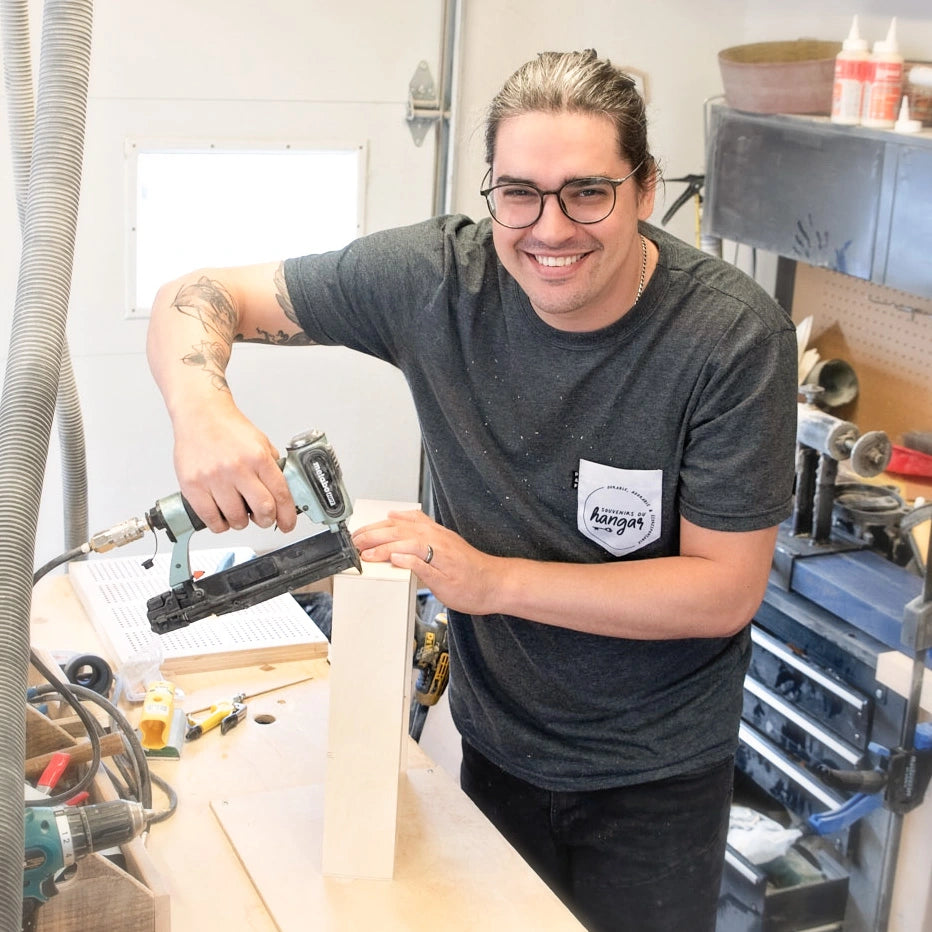 Keven Dufour, l'artisan derrière Souvenirs du Hangar, travaillant à la réalisation d'une valise de naissance dans son atelier au Québec