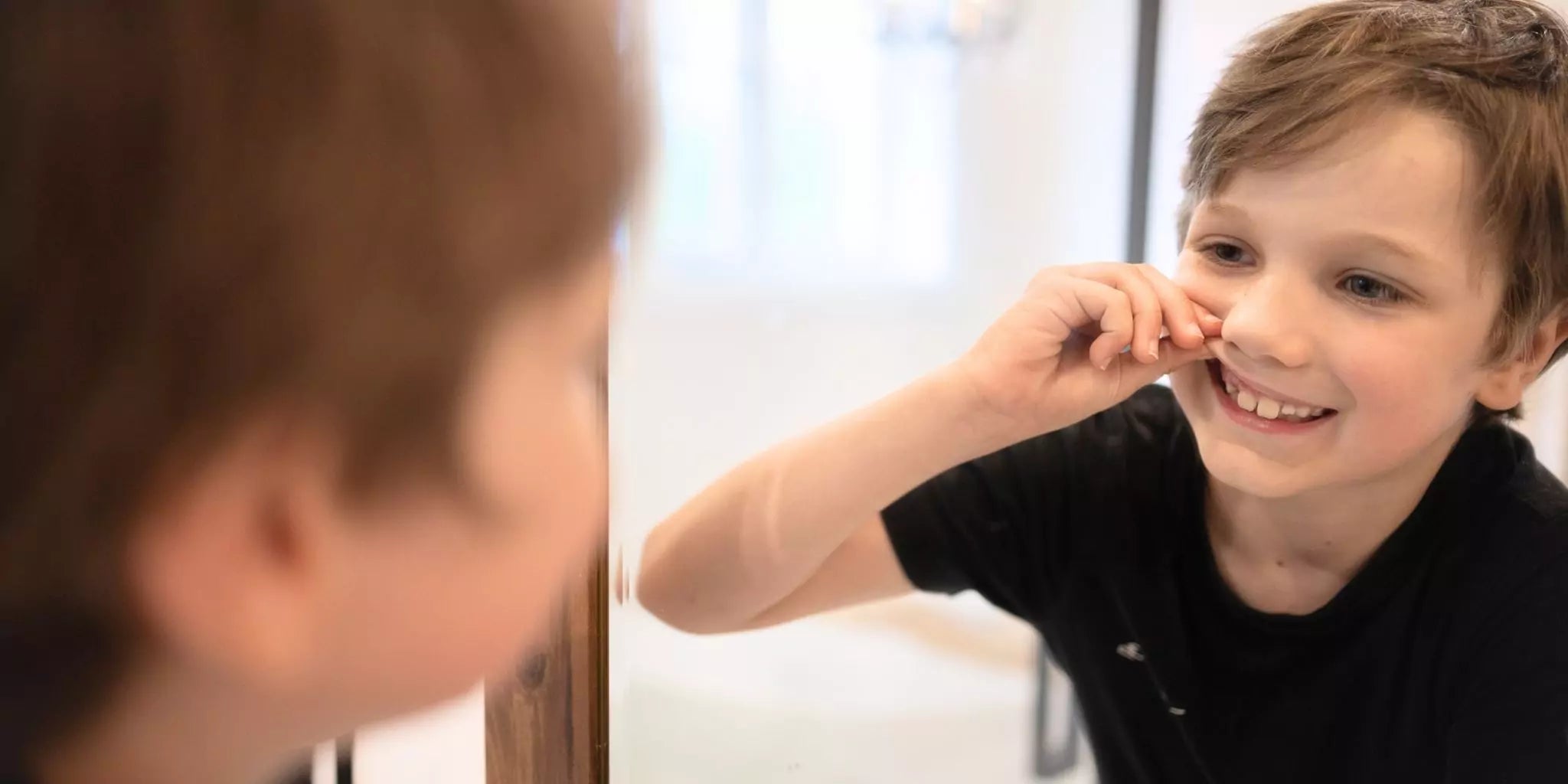 Un enfant a perdu une dent de lait et la placera dans la boite à dents