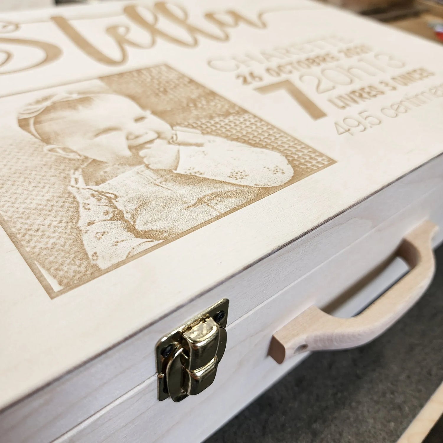 Gros plan sur la gravure sur bois de la valise de naissance qui peut être personnalisée d'une photographie sur mesure